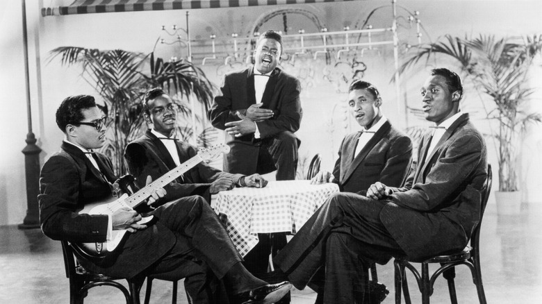 The Moonglows suited performing around restaurant table