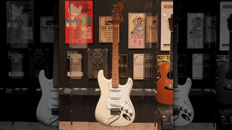 White Vintage Stratocaster on display posters in background