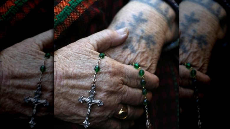 Woman rosary tattoo