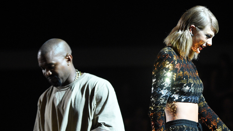 Taylor Swift and Kanye West facing away from each other onstage