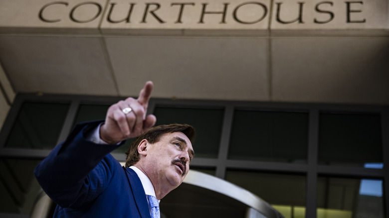 Mike Lindell gesturing in front of a courthouse