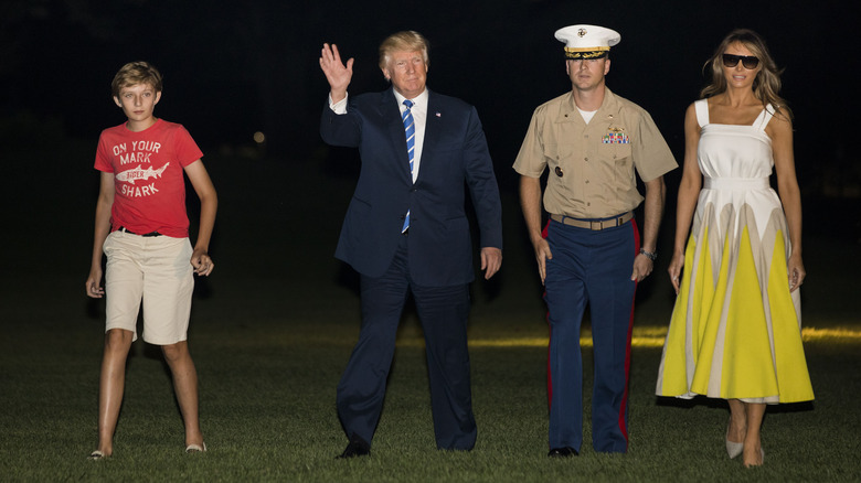 Barron Trump walking with his parents and a military escort