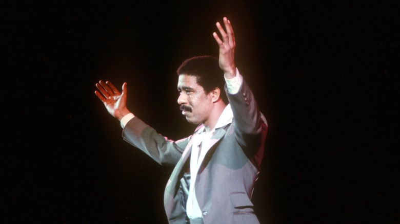 Richard Pryor onstage with hands raised