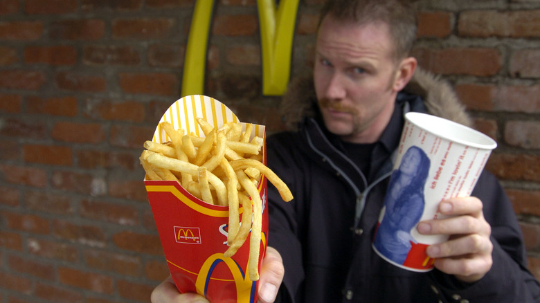 Morgan Spurlock holding fries and a drink