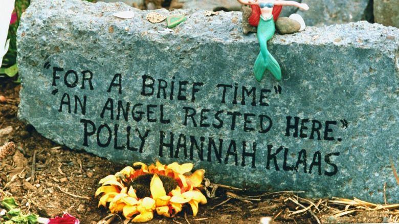 stone with polly klaas memorial inscription sunflower and toy