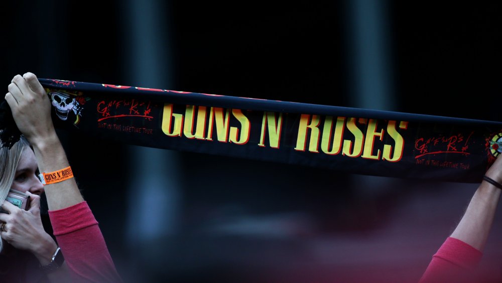 A Guns N' Roses banner held up by a fan at a concert