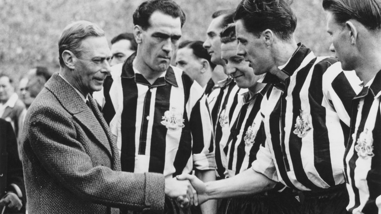 George VI shaking hands with soccer players