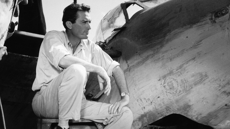Gregory Peck sitting by a plane