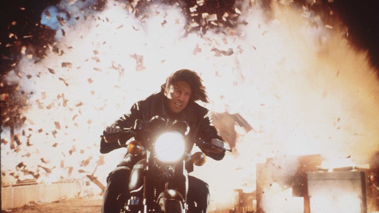 keanu reeves riding away from an explosion