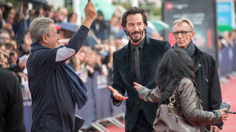 keanu reeves on the red carpet smiling