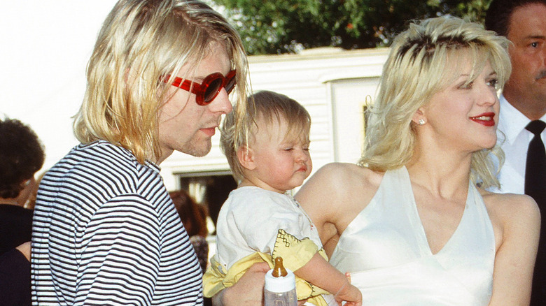 Kurt Cobain, Courtney Love, and Frances Bean looking to the side
