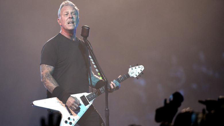 Hetfield plays guitar on stage