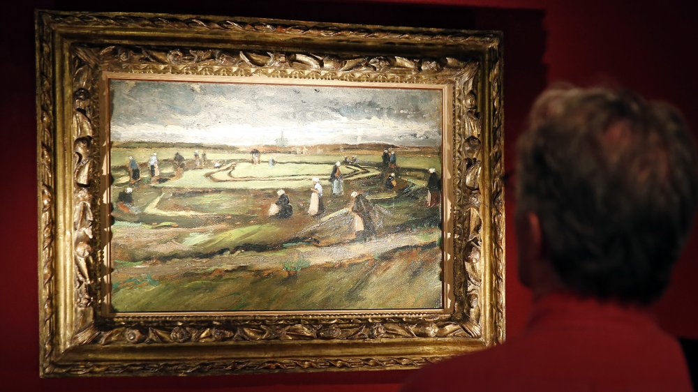 A visitor looks at the painting "Raccommodeuses de filet dans les dunes" (1882)