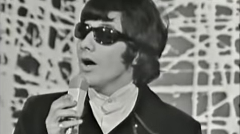 Cat Stevens wearing sunglasses and singing