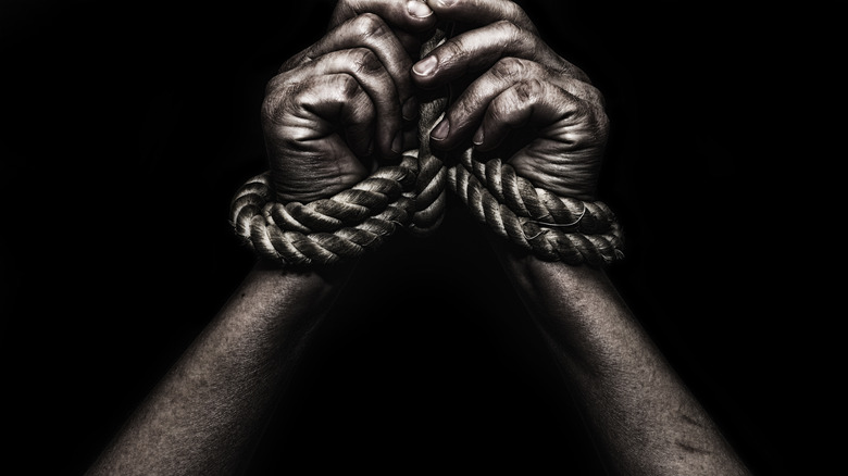 Human hands tied with rope