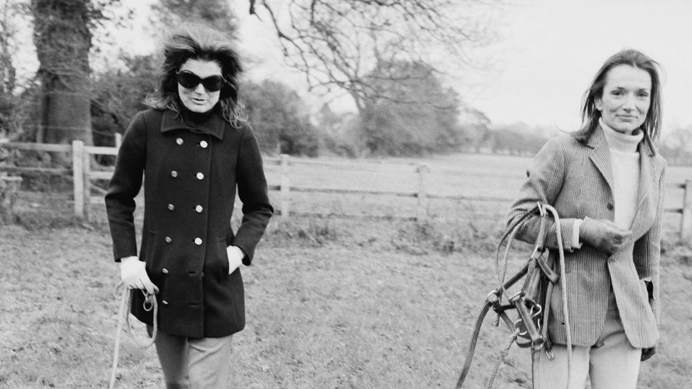 Jackie Kennedy walking in a field with her sister Lee Radziwill