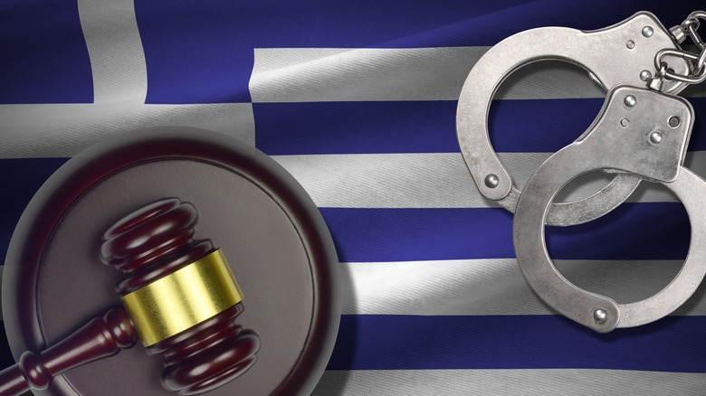 Mallet and handcuffs above Greek flag