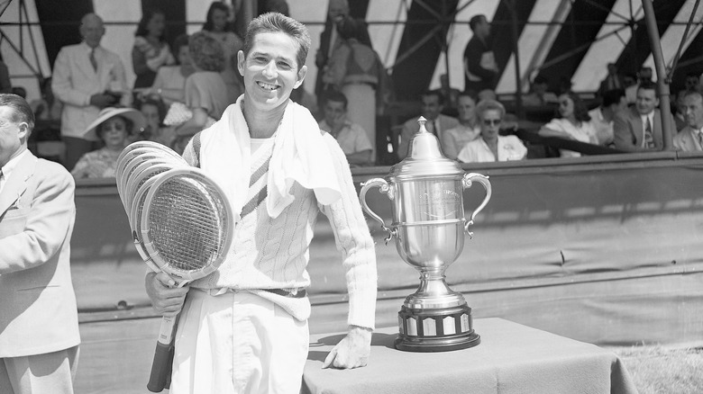 young Bobby Riggs posing with championship trophy