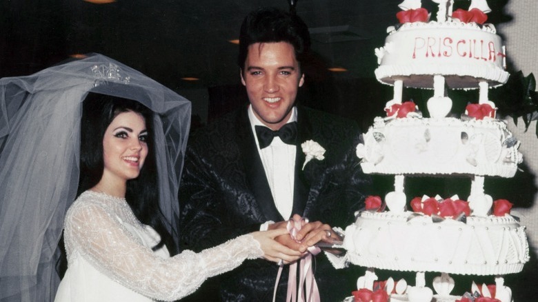 Elvis and Priscilla Presley cutting cake