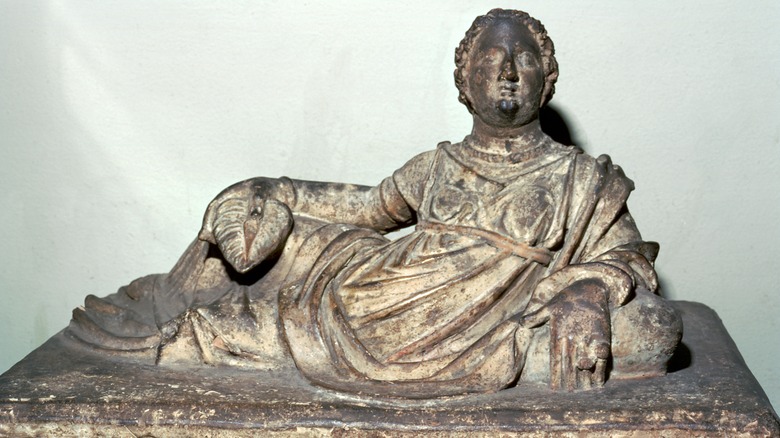 An Etruscan tomb with figure on top