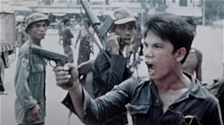 Cambodian soldier holding handgun yelling