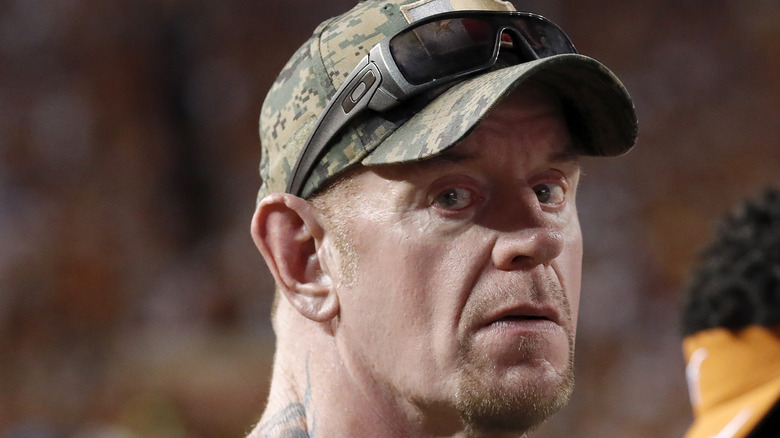The Undertaker in camo hat looking at camera