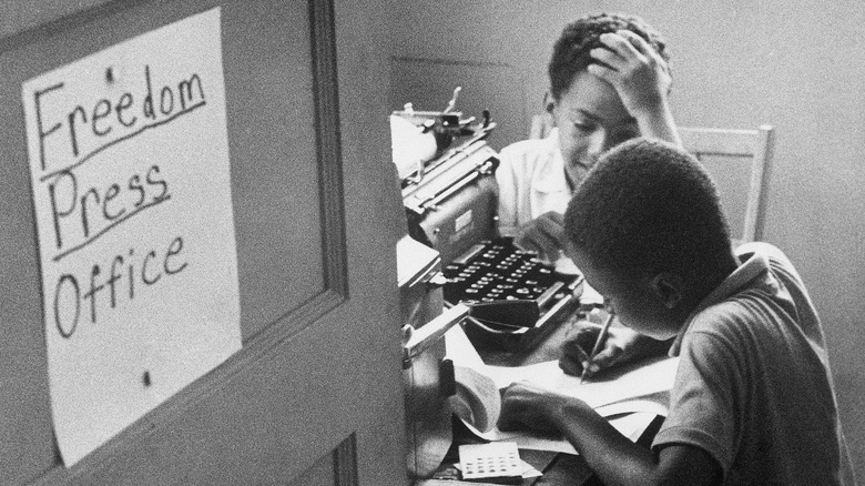 Two African American boys work in the Freedom Press Office