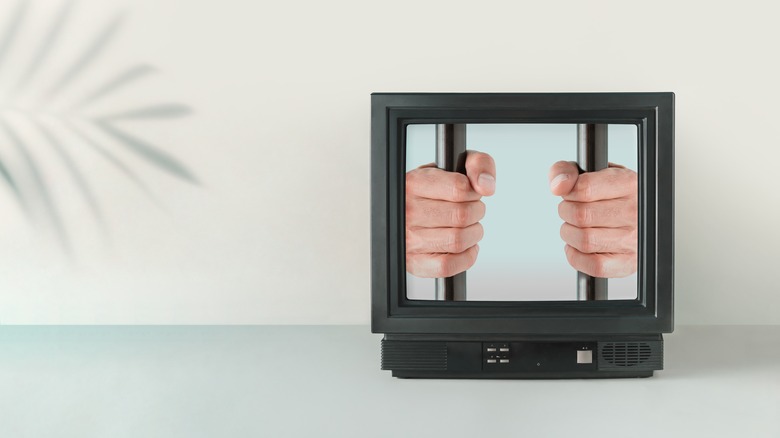 television with man holding prison bars