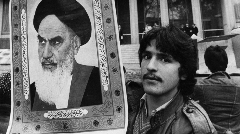 Iranian man holding Khomeini's portrait