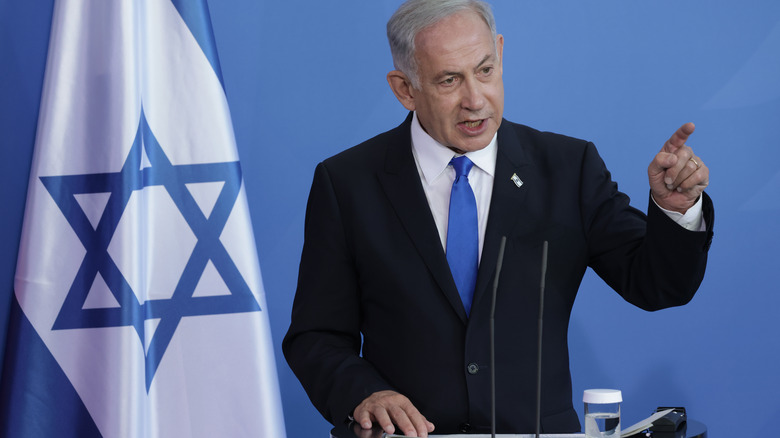 Benjamin Netanyahu next to Israeli flag