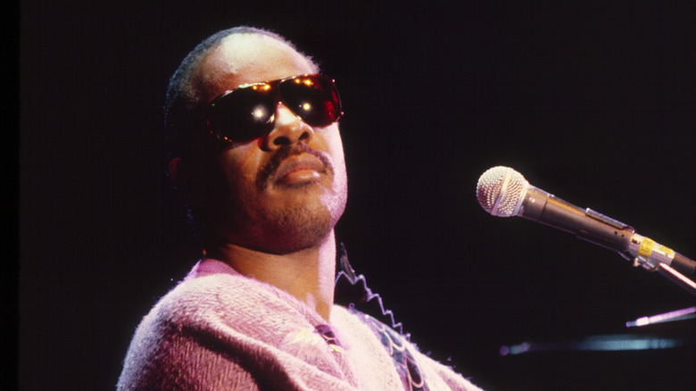 Stevie Wonder seated in front of a microphone