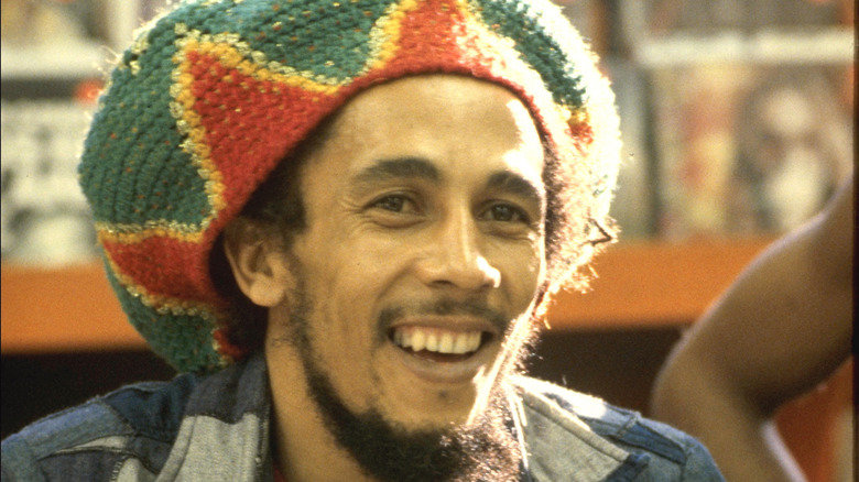 Bob Marley smiling wearing a multicolored hat