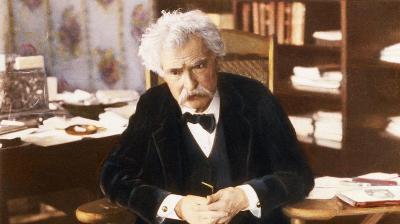 Mark Twain sitting at desk