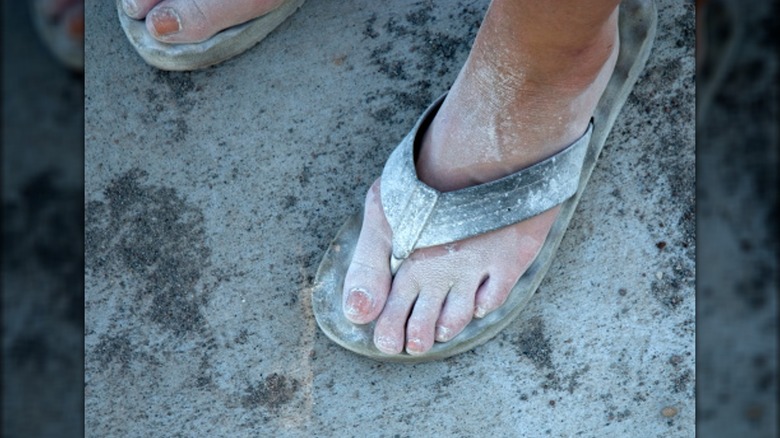 feet flipflops covered with dust