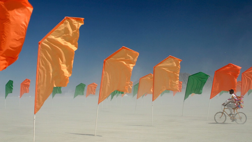 Orange flags waving dusty desert wind