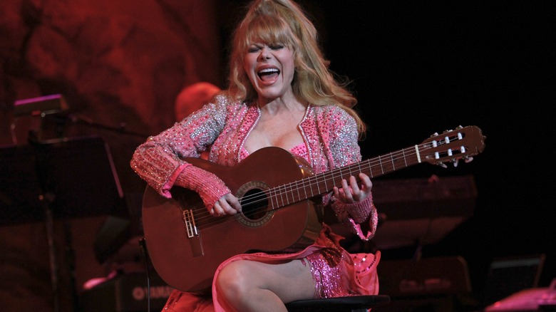 Charo playing guitar and singing on stage