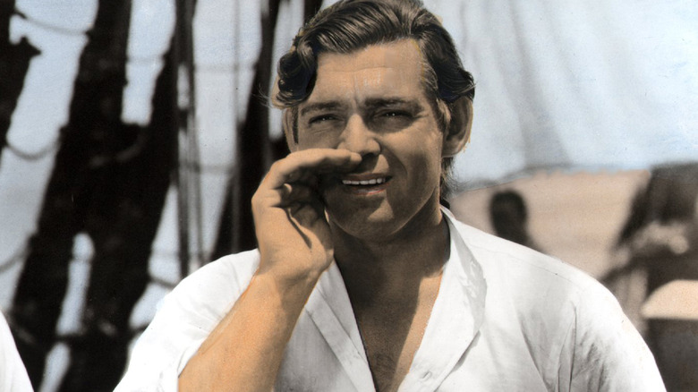 Clark Gable with hand to face, speaking