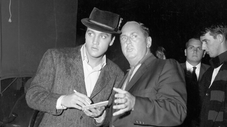 Elvis Presley talking with Colonel Tom Parker in 1957