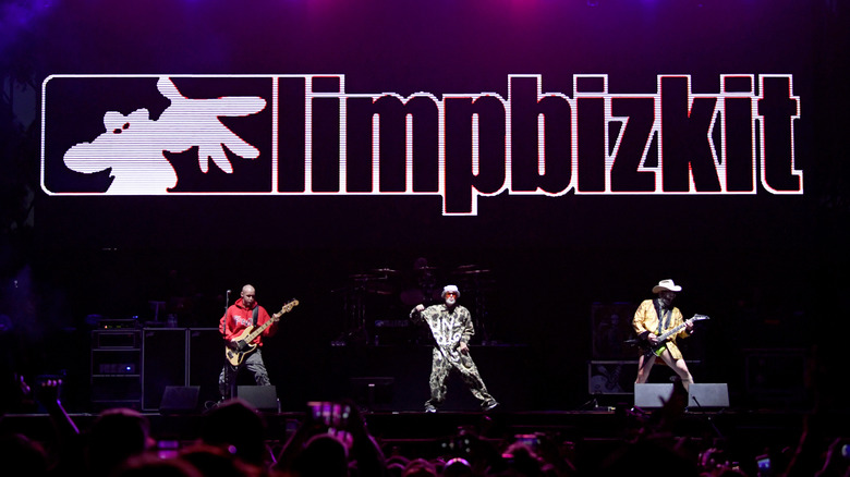 Limp Bizkit, and their logo, loom over a crowd