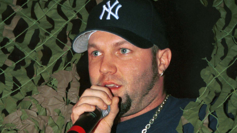 Fred Durst peeks through a green mesh at a concert
