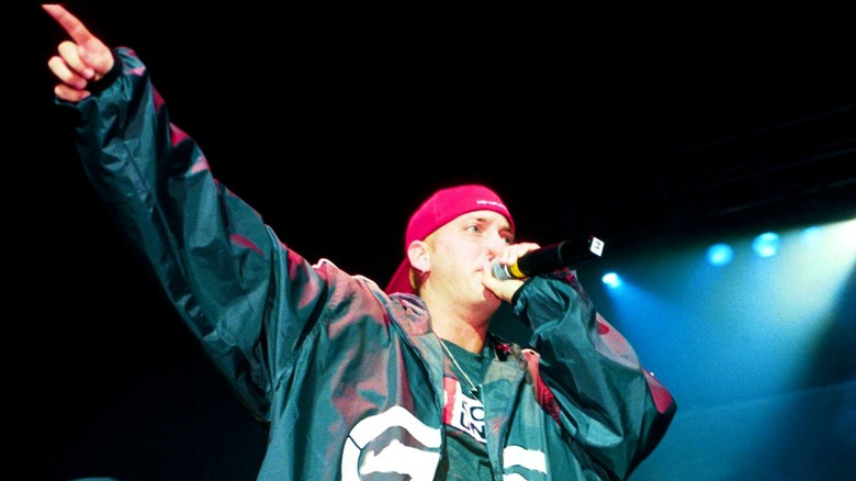 Eminem points off-stage at a concert