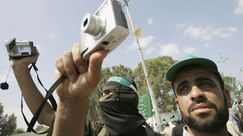 people holding cameras wearing Hamas green