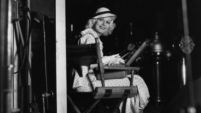 Jean Harlow sits in chair on set