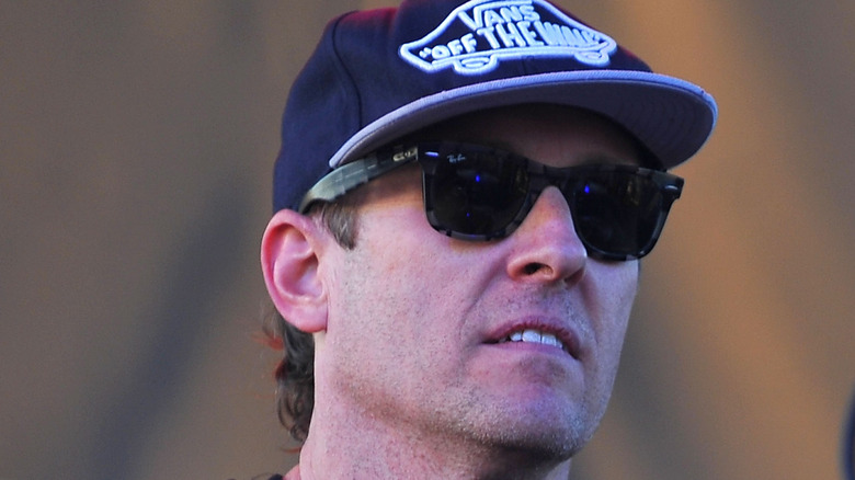 Josh Freese wearing Vans cap and sunglasses