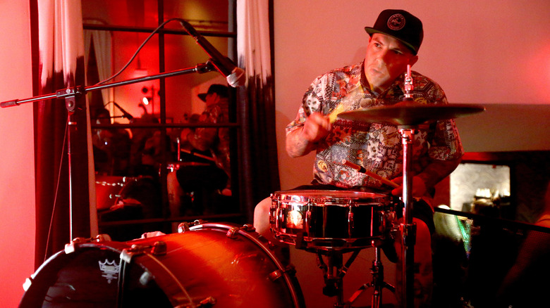 Josh Freese playing drums in red-lit room