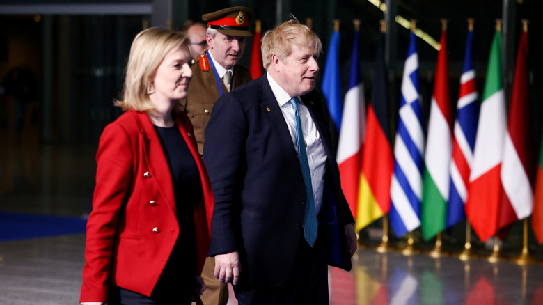 Liz Truss and Boris Johnson in front of flags