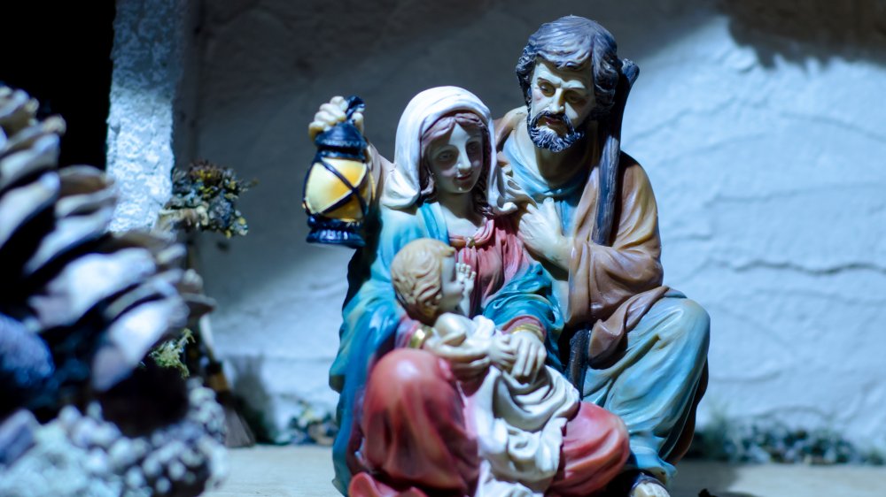 Joseph holding lantern for Mary and baby Jesus