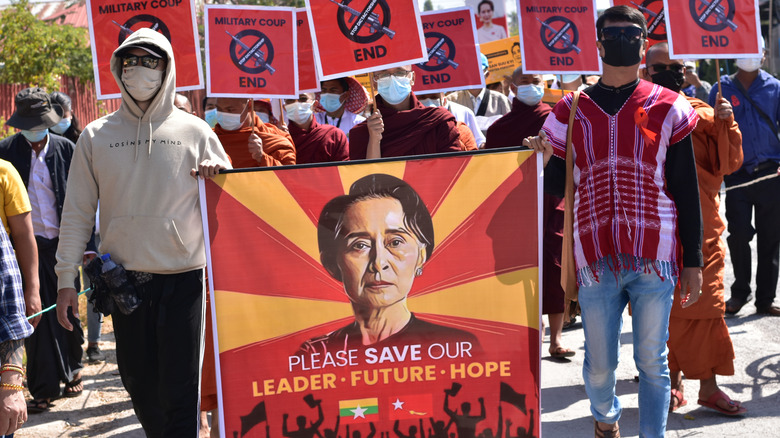 Protestors carry a sign in support of Aung San Suu Kyi