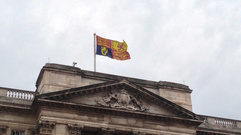 Cropped photo by Conay of the Royal Standard flying over Buckingham Palace, https://creativecommons.org/licenses/by-sa/3.0/