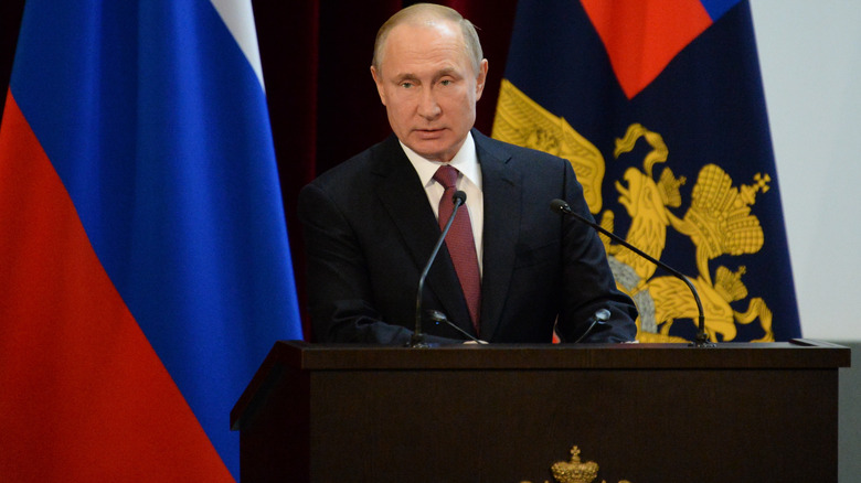 Vladimir Putin in front of flags